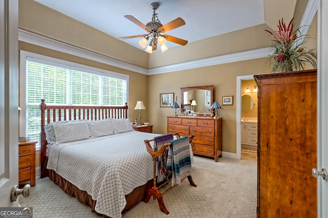 bedroom featuring baseboards, ensuite bathroom, ceiling fan, and light colored carpet