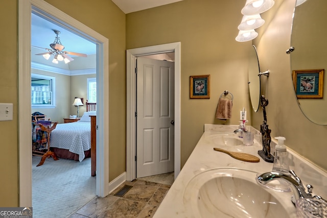 bathroom with double vanity, a sink, connected bathroom, and baseboards