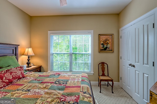 bedroom featuring light colored carpet, baseboards, and a closet