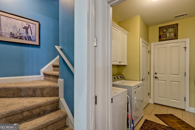 laundry room featuring visible vents, baseboards, washing machine and clothes dryer, cabinet space, and light tile patterned floors