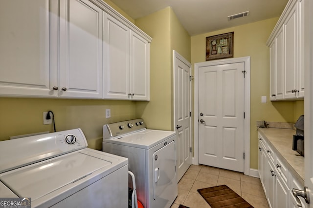 laundry area with cabinet space, visible vents, light tile patterned floors, and washer and dryer