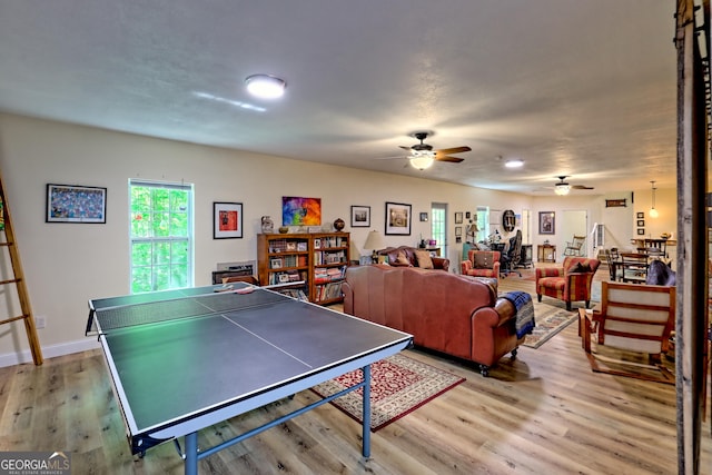 playroom featuring baseboards, light wood-style flooring, and ceiling fan