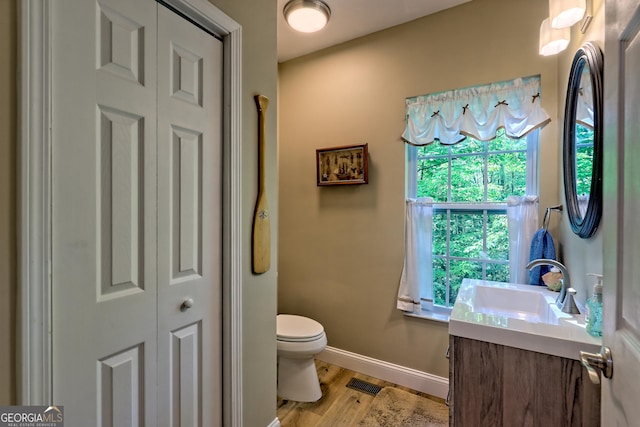 bathroom with visible vents, wood finished floors, baseboards, a closet, and toilet