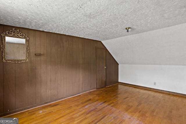 7255 Blue Ridge Dr, Blue Ridge, GA 30513 - bonus room with a textured ceiling, wood walls, hardwood / wood-style floors, baseboards, and vaulted ceiling
