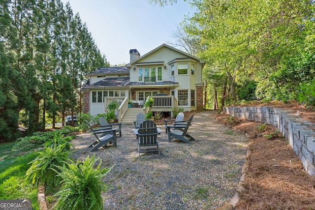 4584 E Conway Dr, Atlanta, GA 30327 - rear view of house featuring a chimney, an outdoor fire pit, stairway, and brick siding
