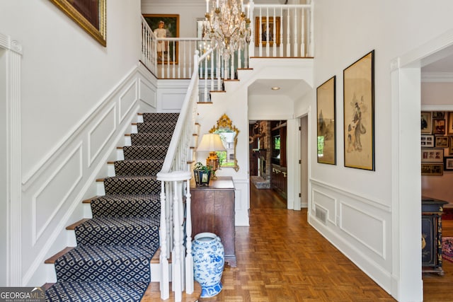 4584 E Conway Dr, Atlanta, GA 30327 - entryway featuring a chandelier, wainscoting, stairway, and a decorative wall