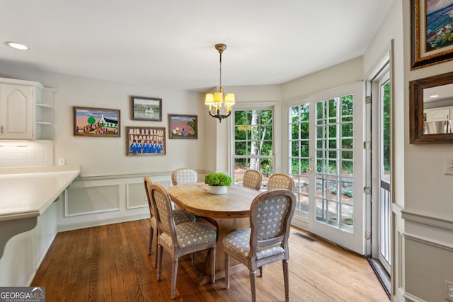 4584 E Conway Dr, Atlanta, GA 30327 - dining area with a notable chandelier, a decorative wall, light wood-style flooring, a wainscoted wall, and visible vents