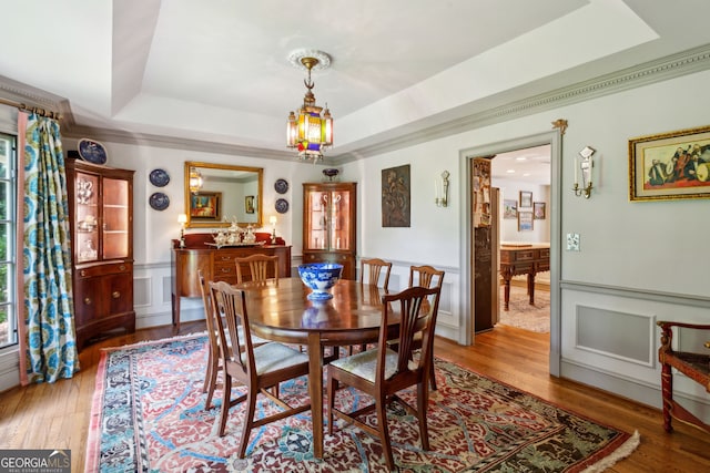 4584 E Conway Dr, Atlanta, GA 30327 - dining space featuring light wood-type flooring, a raised ceiling, and a decorative wall