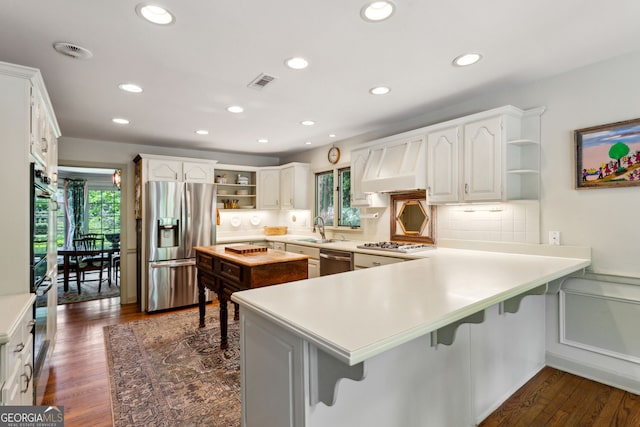 4584 E Conway Dr, Atlanta, GA 30327 - kitchen featuring visible vents, open shelves, premium range hood, a peninsula, and stainless steel appliances