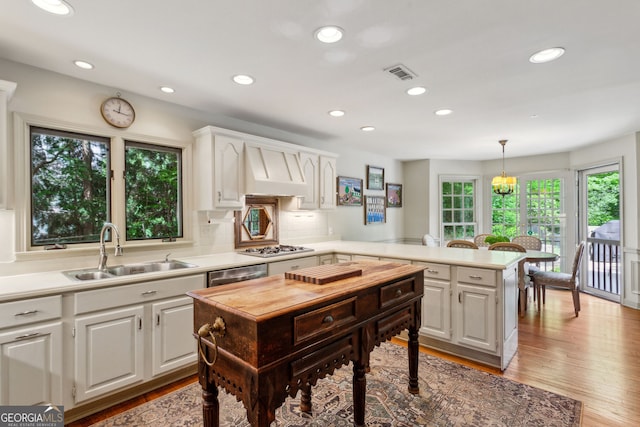 4584 E Conway Dr, Atlanta, GA 30327 - kitchen with visible vents, a peninsula, white cabinetry, custom range hood, and a sink