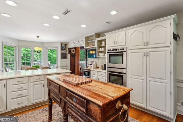 4584 E Conway Dr, Atlanta, GA 30327 - kitchen with visible vents, double oven, light countertops, white cabinetry, and light wood finished floors