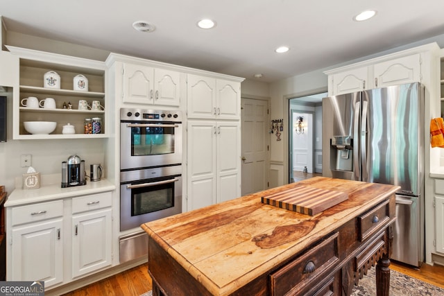 4584 E Conway Dr, Atlanta, GA 30327 - kitchen with white cabinets, stainless steel appliances, light wood finished floors, and a warming drawer