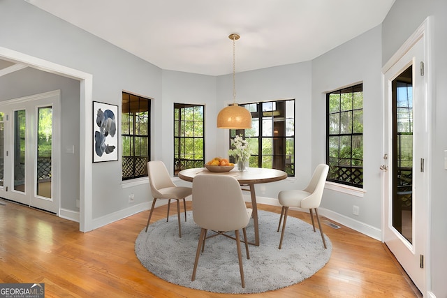 dining area featuring a healthy amount of sunlight, baseboards, light wood finished floors, and visible vents