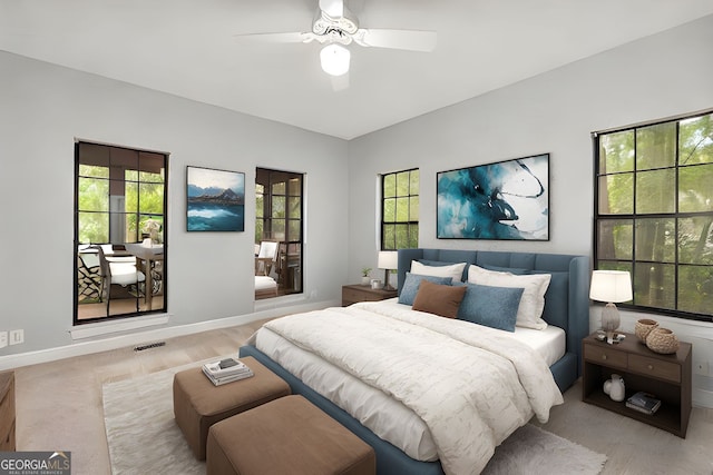 bedroom featuring baseboards, ceiling fan, and multiple windows