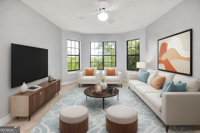 living area with baseboards and ceiling fan