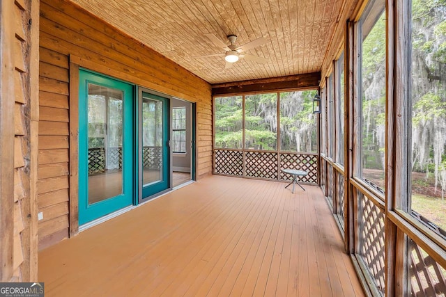 unfurnished sunroom featuring a ceiling fan and a healthy amount of sunlight