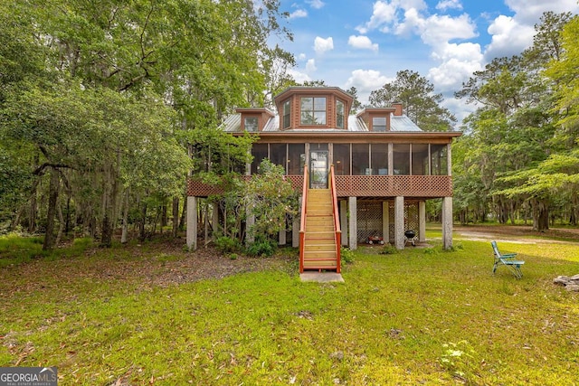 rear view of property with a lawn, stairs, and a sunroom