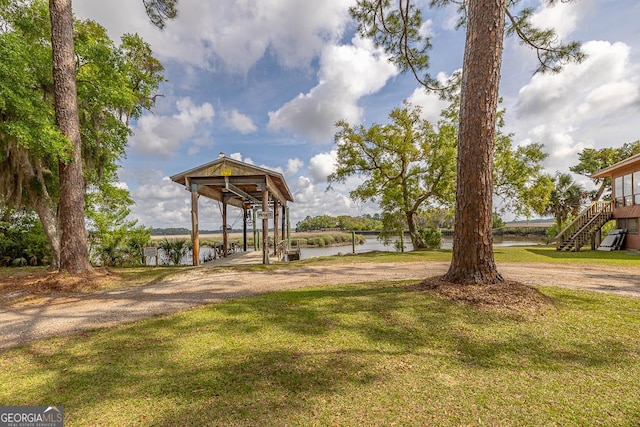 surrounding community featuring a yard, a water view, and stairs