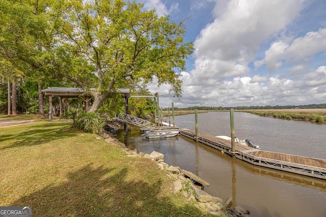 view of dock with a water view and a yard
