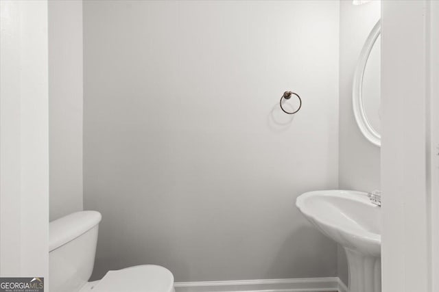 145 Redsage Rdg, Atlanta, GA 30349 - half bathroom with toilet, baseboards, and a sink