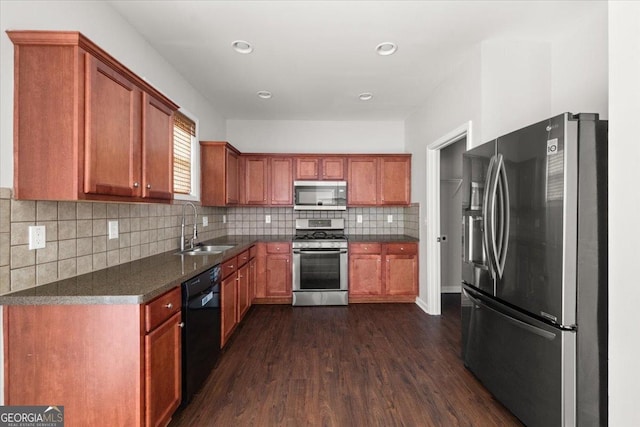 145 Redsage Rdg, Atlanta, GA 30349 - kitchen with appliances with stainless steel finishes, a sink, dark countertops, dark wood-style floors, and backsplash
