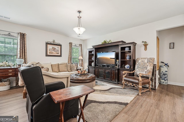living room featuring light wood finished floors, plenty of natural light, and baseboards