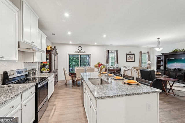 kitchen with electric range, a sink, under cabinet range hood, light wood-type flooring, and recessed lighting