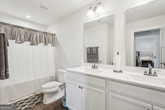 full bathroom with wood finished floors, double vanity, toilet, and shower / tub combo with curtain