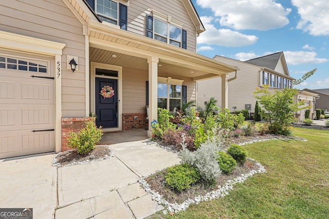 property entrance with brick siding, covered porch, a lawn, and an attached garage