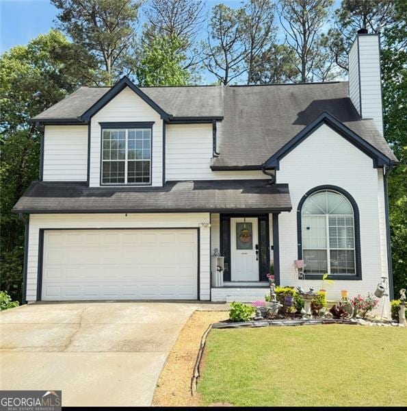 view of front of home with a garage, a porch, a front yard, a chimney, and concrete driveway