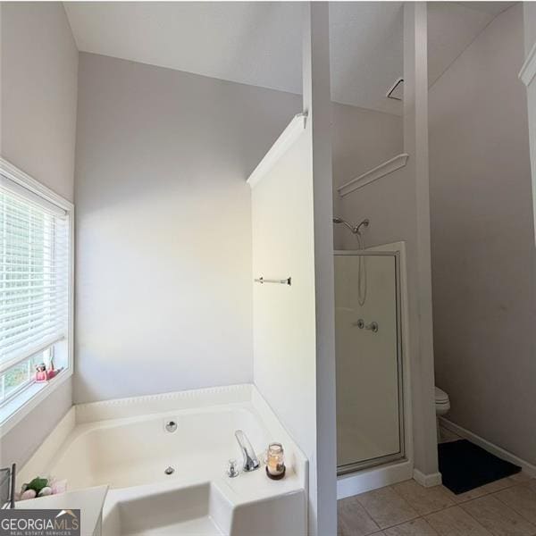 bathroom featuring a garden tub, tile patterned floors, toilet, and a shower stall