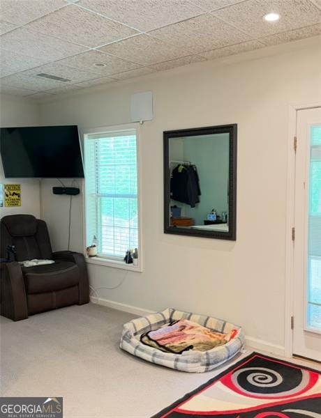 living area featuring baseboards and carpet flooring