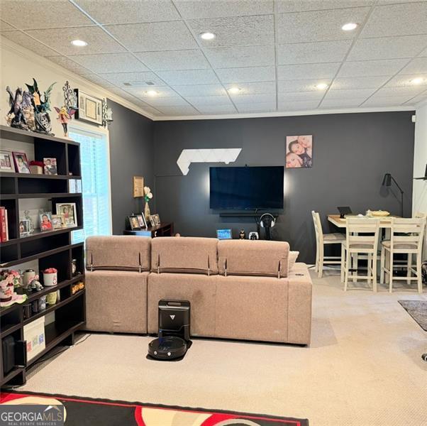 living area featuring crown molding and recessed lighting