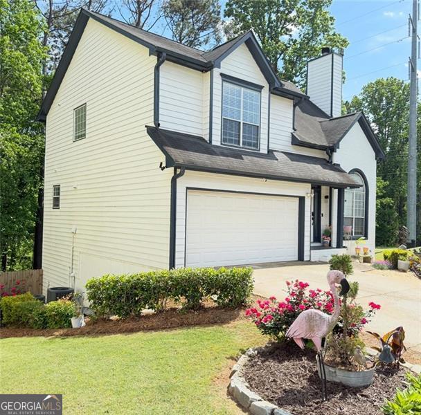 view of side of home with fence, a garage, a chimney, a lawn, and driveway