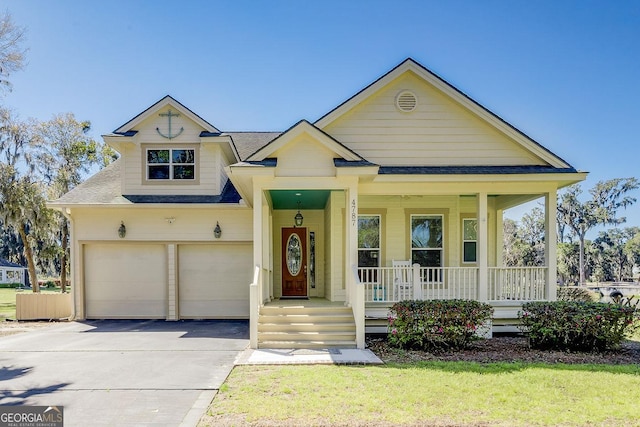 view of front of house with a porch, a shingled roof, a garage, and driveway