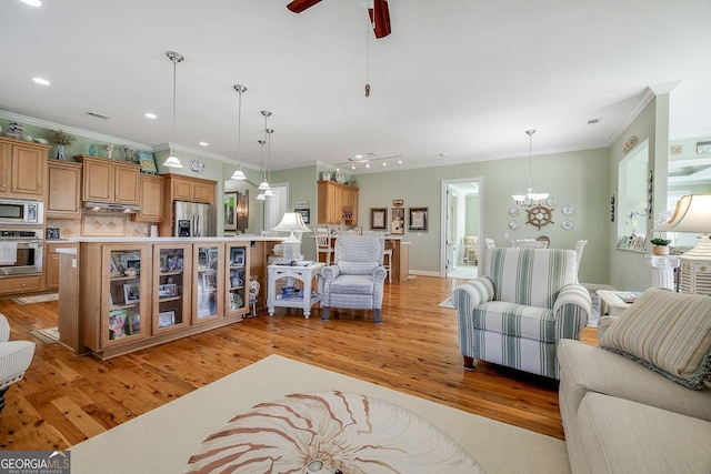 living area featuring recessed lighting, ornamental molding, light wood-style flooring, and ceiling fan with notable chandelier