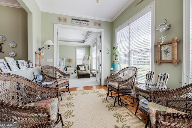 sitting room with crown molding, plenty of natural light, and light wood-type flooring