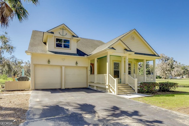 view of front of property with roof with shingles, covered porch, an attached garage, and driveway