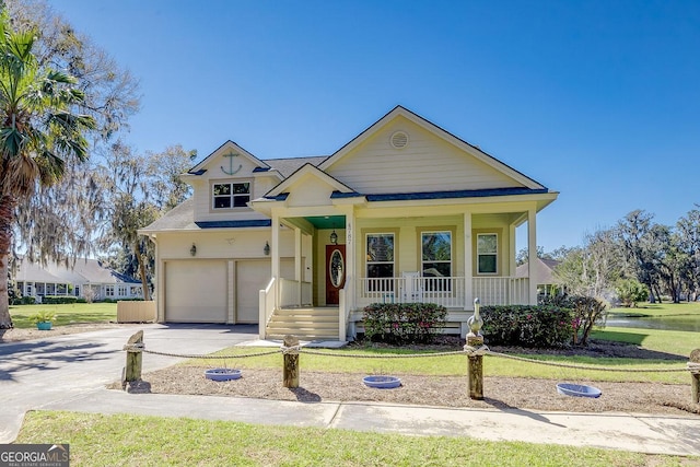 view of front of property featuring a garage, a porch, driveway, and a front yard