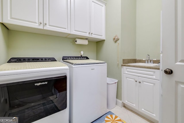 clothes washing area with a sink, cabinet space, independent washer and dryer, and light tile patterned floors