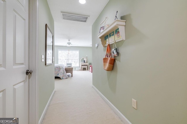 corridor with carpet flooring, baseboards, and visible vents
