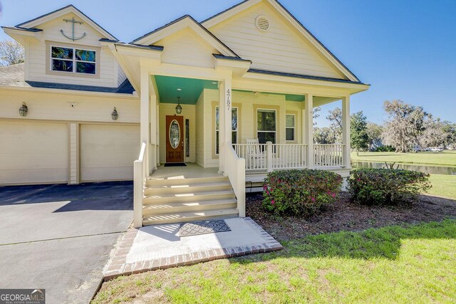 view of front of property with covered porch, an attached garage, and aphalt driveway