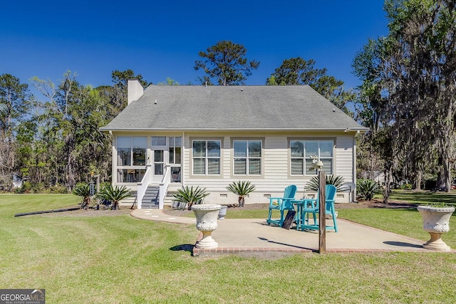back of house featuring a lawn, a patio, crawl space, and a chimney
