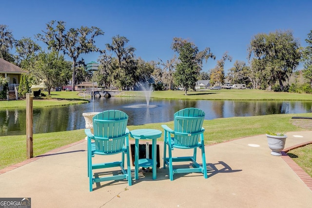 surrounding community featuring a lawn and a water view