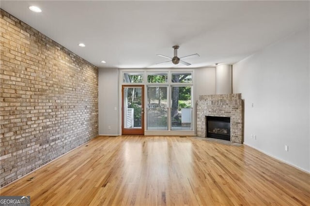 1294 Fernwood Cir NE, Brookhaven, GA 30319 - unfurnished living room with a fireplace, brick wall, a ceiling fan, baseboards, and wood finished floors