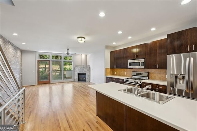1294 Fernwood Cir NE, Brookhaven, GA 30319 - kitchen with appliances with stainless steel finishes, a sink, light countertops, a glass covered fireplace, and backsplash