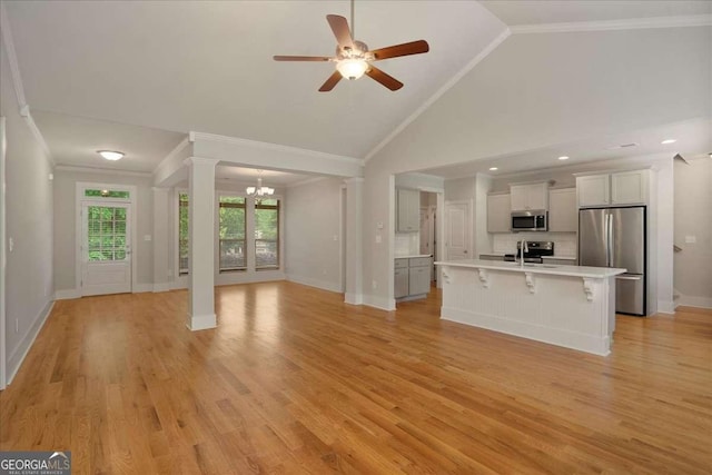 unfurnished living room with crown molding, a sink, light wood-style floors, ceiling fan with notable chandelier, and baseboards