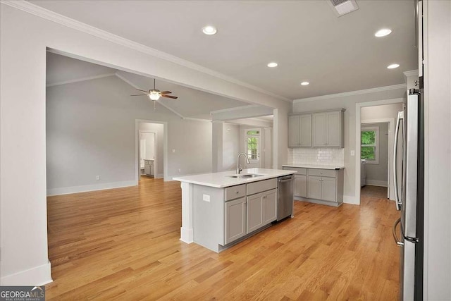kitchen with appliances with stainless steel finishes, gray cabinetry, a wealth of natural light, and a sink