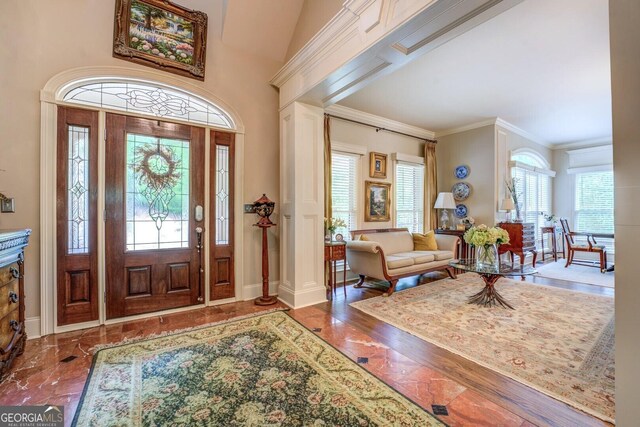 foyer with baseboards and ornamental molding