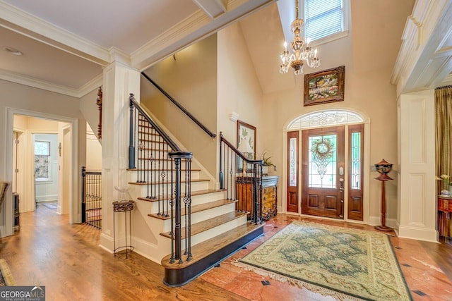 foyer featuring a healthy amount of sunlight, stairs, and wood finished floors